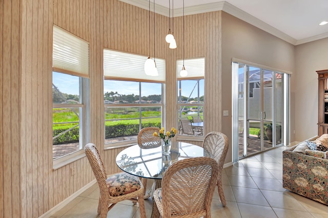 tiled dining space with a wealth of natural light, wood walls, and ornamental molding