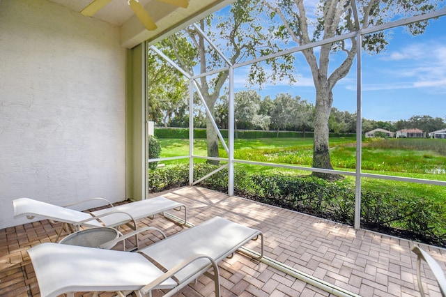 unfurnished sunroom with ceiling fan