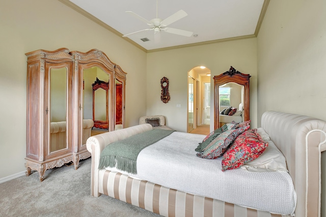 carpeted bedroom with ceiling fan, ornamental molding, and ensuite bath