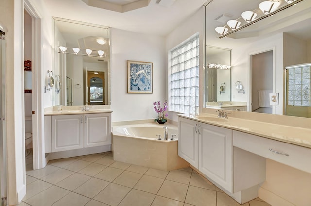 bathroom featuring tile patterned floors, vanity, toilet, and a tub to relax in