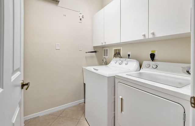 clothes washing area with cabinets, independent washer and dryer, and light tile patterned flooring