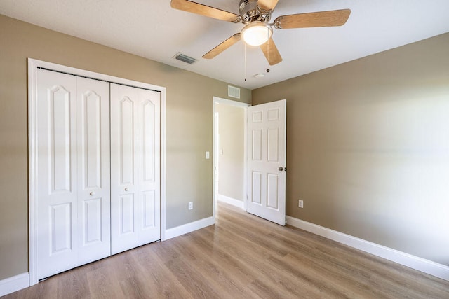 unfurnished bedroom featuring a closet, light hardwood / wood-style floors, and ceiling fan