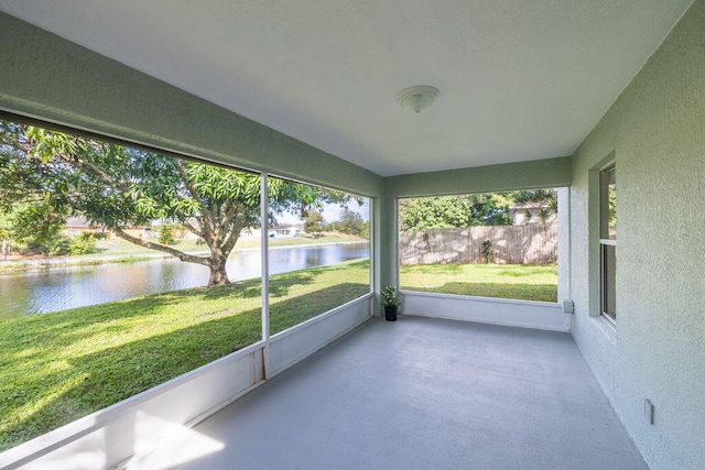 unfurnished sunroom featuring a water view and vaulted ceiling