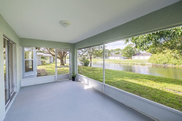 unfurnished sunroom featuring a water view