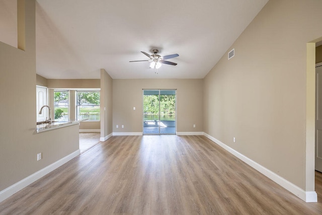 spare room with ceiling fan, a healthy amount of sunlight, and light wood-type flooring