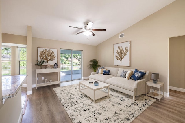 living room with ceiling fan, dark hardwood / wood-style flooring, and vaulted ceiling