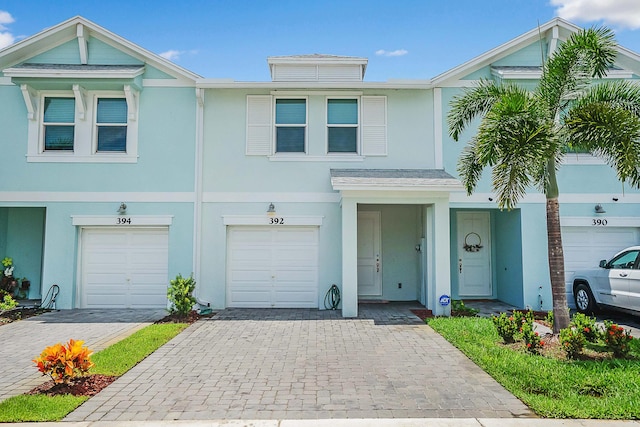 392 SE Sea Hunt Way, Stuart, FL 34994 - townhome / multi-family property with stucco siding, decorative driveway, and a garage