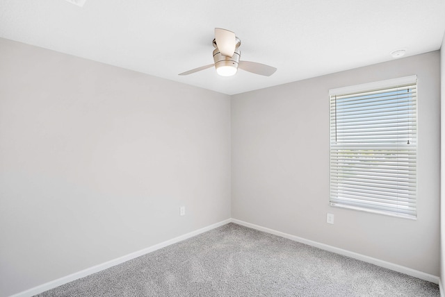 carpeted spare room with ceiling fan