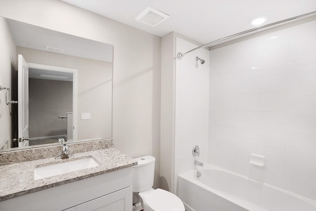 full bathroom featuring tiled shower / bath, vanity, and toilet