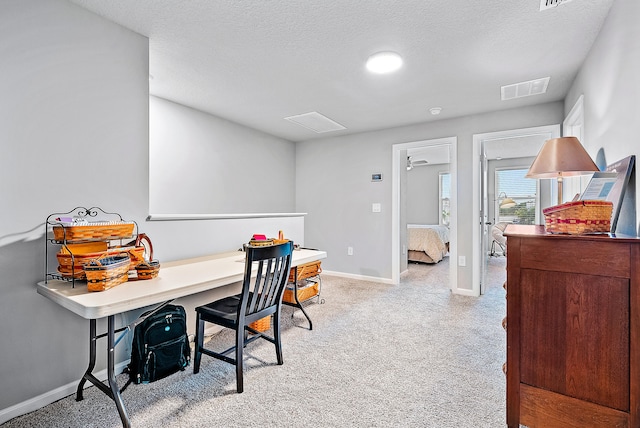 office area featuring light carpet and a textured ceiling