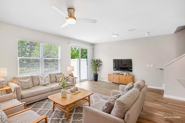 living room with ceiling fan and light hardwood / wood-style flooring