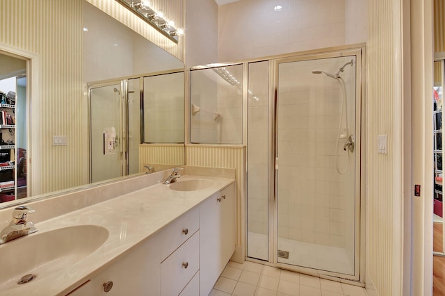 bathroom with tile patterned flooring, a shower with door, and vanity