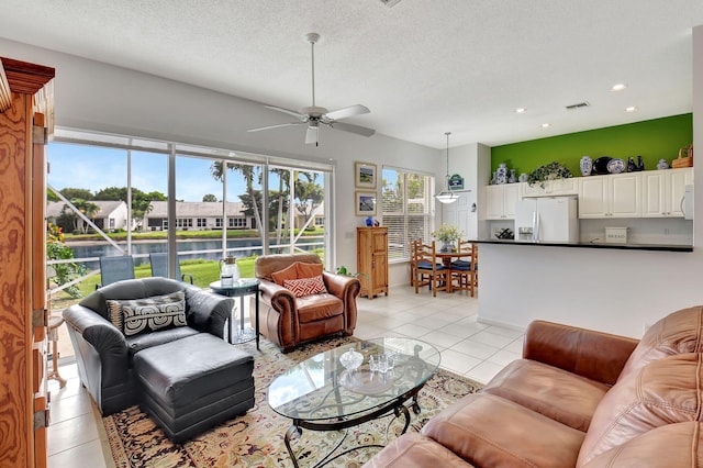 tiled living room featuring ceiling fan and a textured ceiling