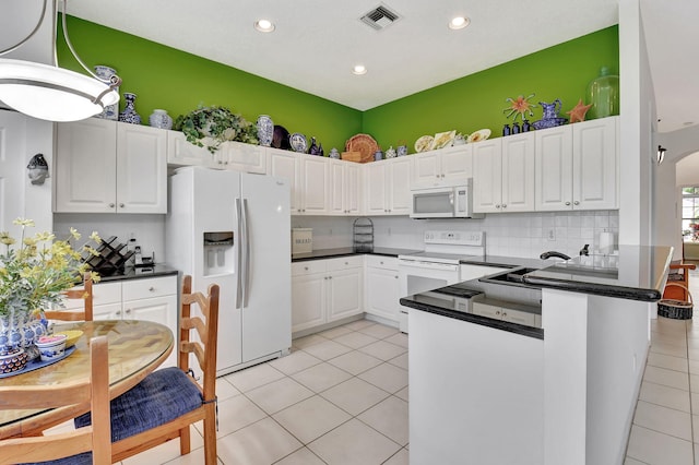 kitchen with white appliances, white cabinets, light tile patterned floors, and pendant lighting