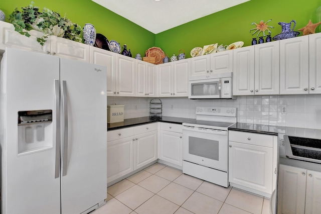 kitchen with white appliances, white cabinetry, backsplash, and light tile patterned floors