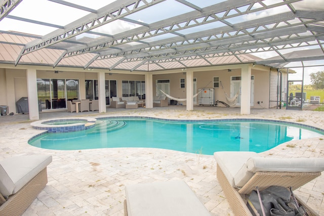 view of pool with outdoor lounge area, a lanai, a patio area, and an in ground hot tub