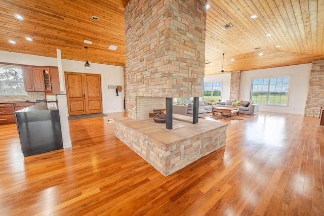 living room featuring light hardwood / wood-style floors, high vaulted ceiling, wooden ceiling, and a stone fireplace