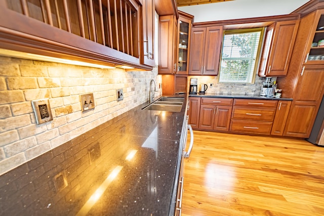 kitchen with light wood-type flooring, backsplash, and sink