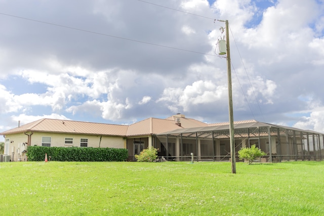 back of property featuring a yard, cooling unit, and a lanai