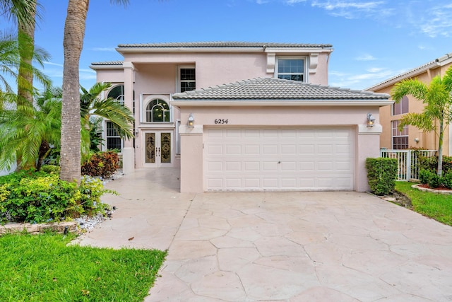 mediterranean / spanish house featuring french doors and a garage