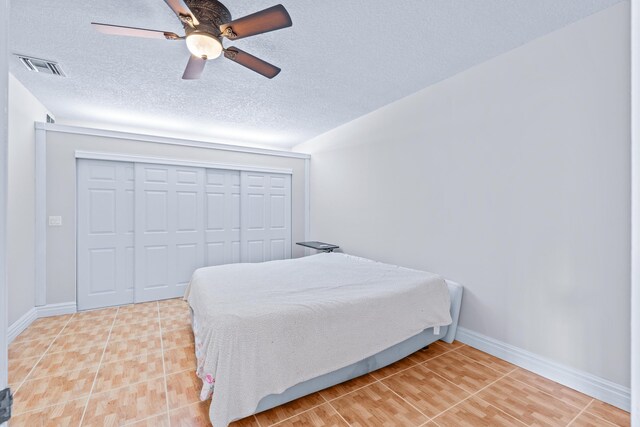 bedroom featuring ceiling fan, a textured ceiling, and a closet