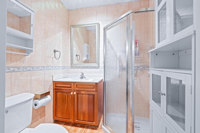 bathroom featuring an enclosed shower, hardwood / wood-style floors, vanity, and tile walls