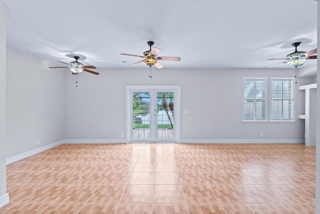 spare room with ceiling fan, a healthy amount of sunlight, and light tile patterned floors