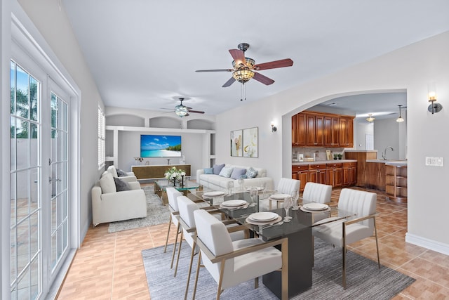 tiled dining space with ceiling fan and sink