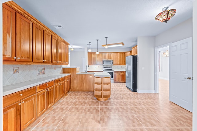 kitchen with a kitchen island, decorative light fixtures, decorative backsplash, light tile patterned floors, and appliances with stainless steel finishes