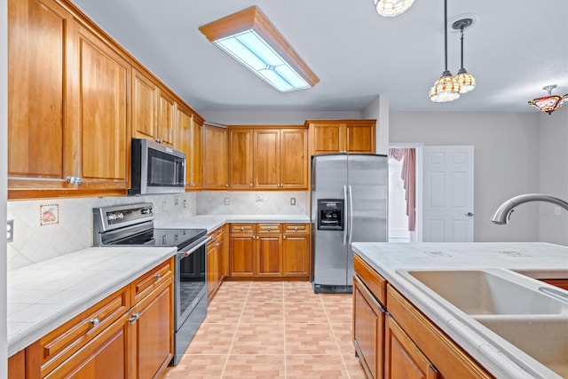 kitchen with sink, hanging light fixtures, stainless steel appliances, decorative backsplash, and light tile patterned flooring