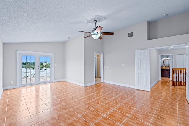 interior space with ceiling fan, light tile patterned floors, a textured ceiling, and high vaulted ceiling