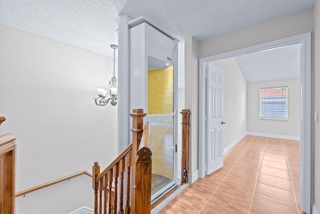 corridor featuring light tile patterned floors and a textured ceiling