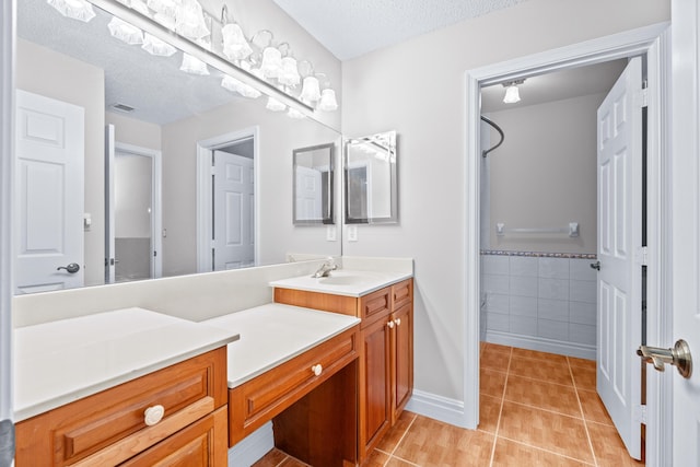 bathroom featuring tile patterned floors, vanity, and a textured ceiling