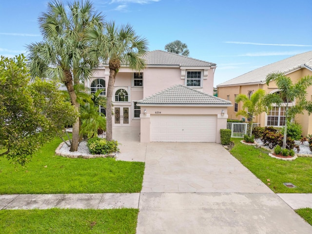 mediterranean / spanish home with a garage and a front yard