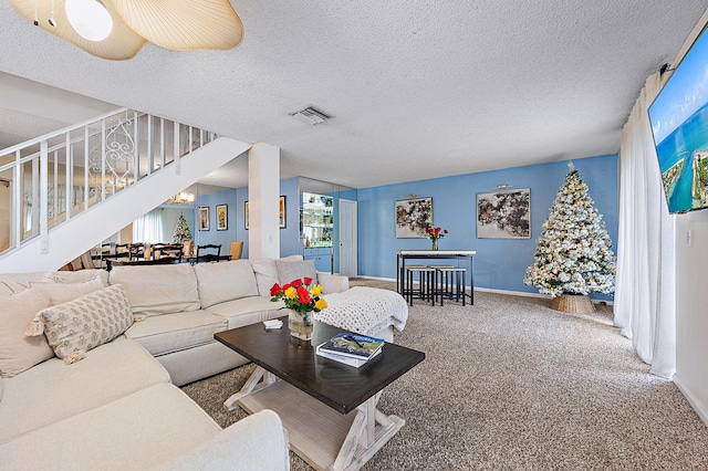 carpeted living room with ceiling fan and a textured ceiling