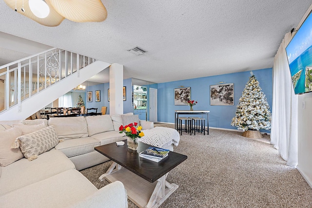 living room with stairway, carpet floors, baseboards, and a textured ceiling