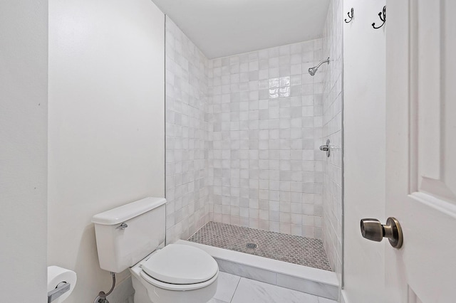bathroom with toilet and a tile shower