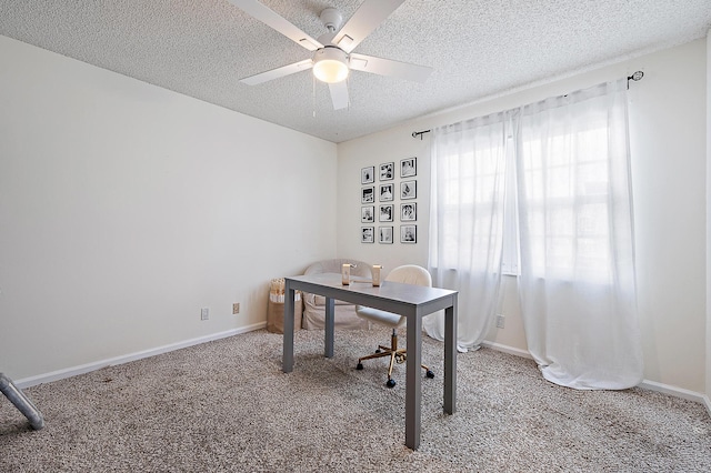 carpeted home office with a textured ceiling and ceiling fan