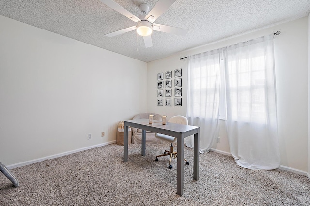 carpeted office space featuring a textured ceiling, a ceiling fan, and baseboards