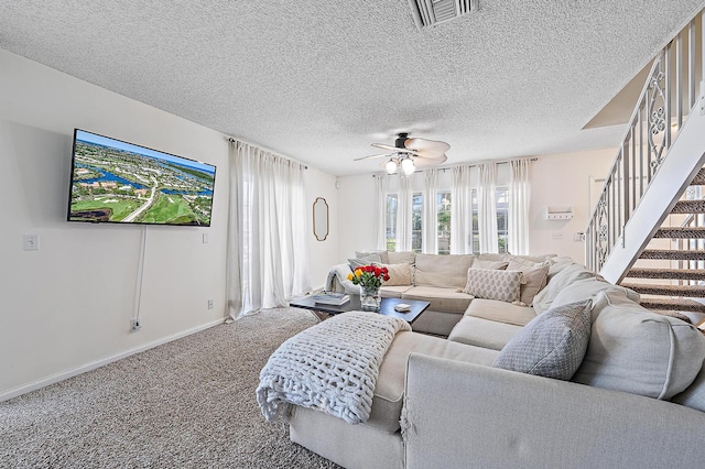 living room featuring carpet flooring, a ceiling fan, stairway, baseboards, and a textured ceiling