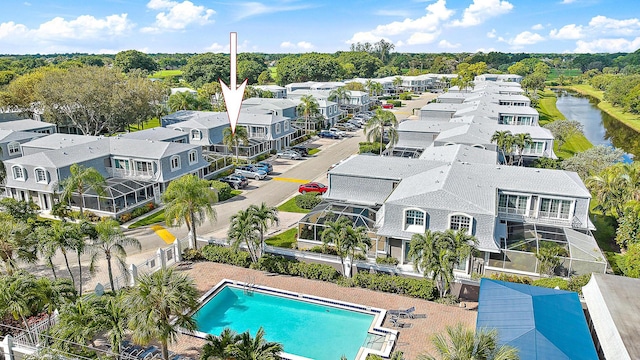 drone / aerial view of a pool area and a large body of water