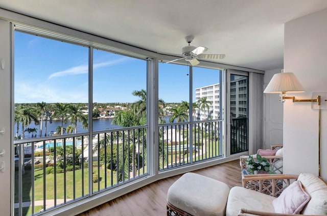 sunroom / solarium with a water view and ceiling fan