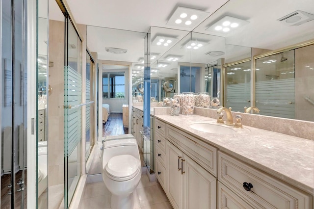 bathroom featuring toilet, vanity, tile patterned floors, and walk in shower