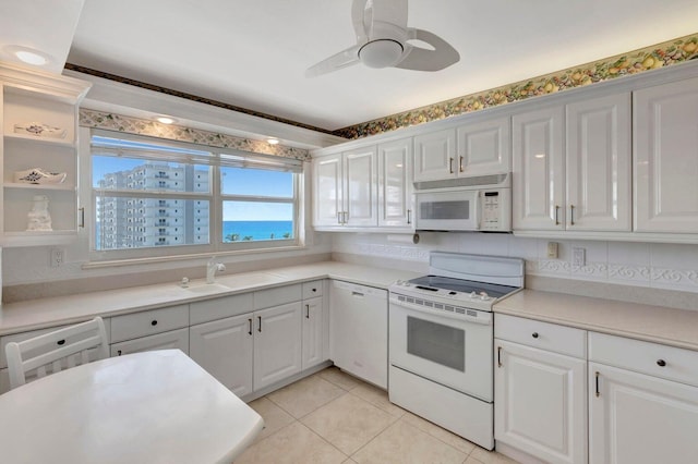 kitchen with white appliances, ceiling fan, sink, light tile patterned floors, and white cabinetry