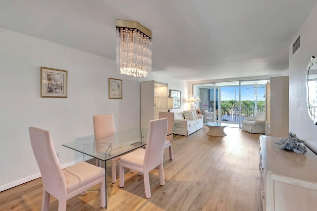 dining space featuring light hardwood / wood-style floors, floor to ceiling windows, and a chandelier