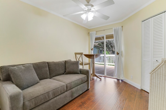 living room featuring ornamental molding, dark wood-type flooring, and ceiling fan