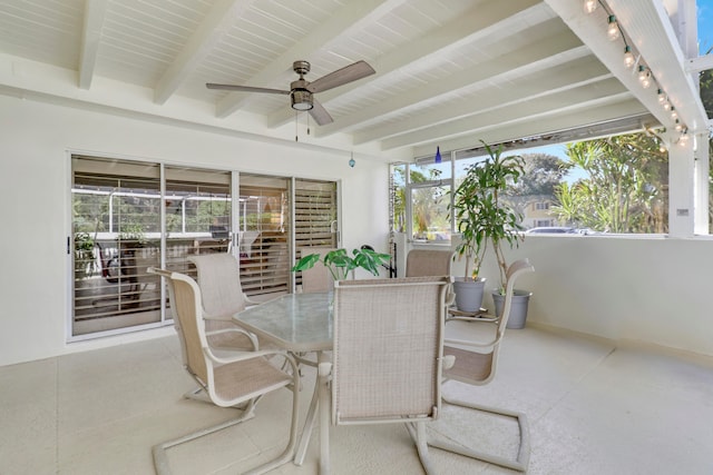 sunroom with ceiling fan, a healthy amount of sunlight, and beamed ceiling