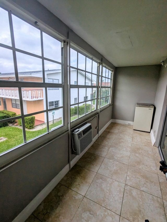 unfurnished sunroom with a wall mounted air conditioner