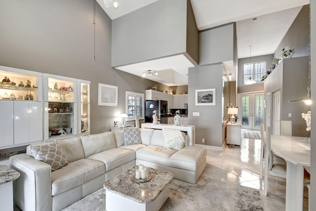 tiled living room with a high ceiling and french doors