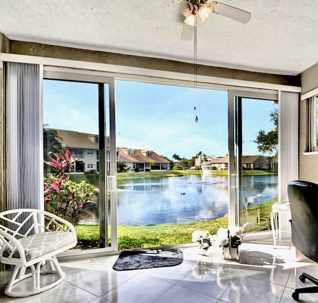 entryway with a healthy amount of sunlight, tile patterned floors, a water view, and a textured ceiling